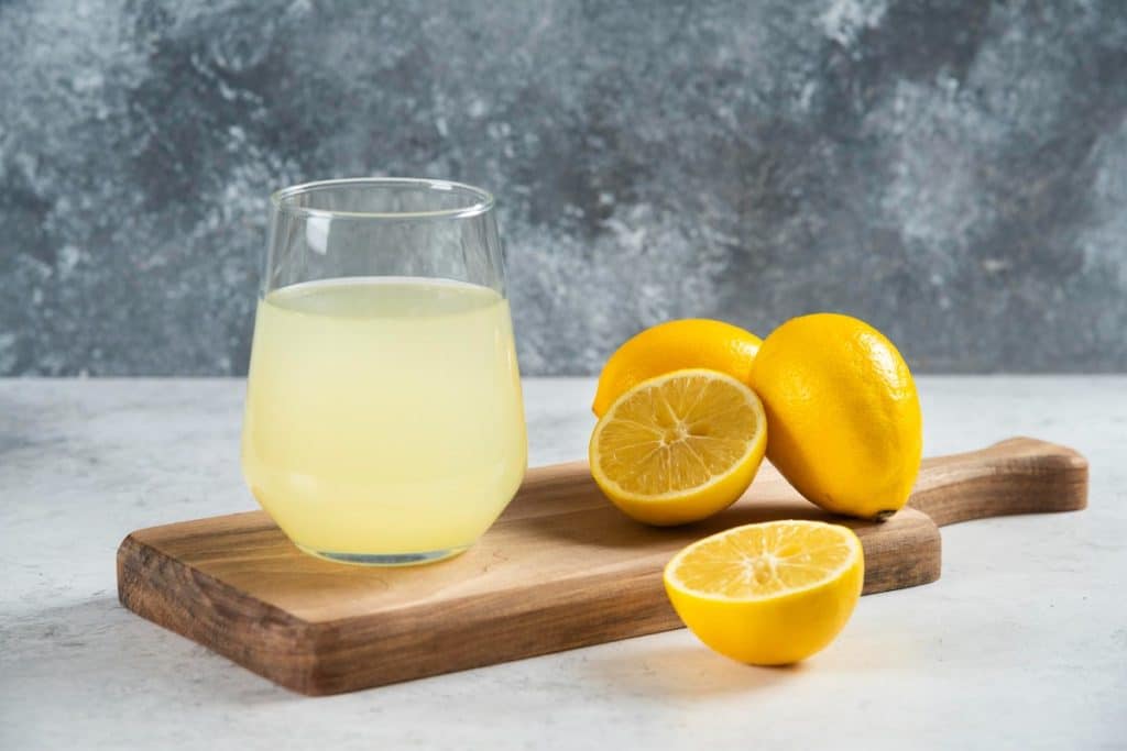 verre de citron avec des citron coupé sur une planche