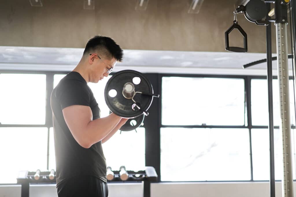 Homme soulevant haltère en salle de sport