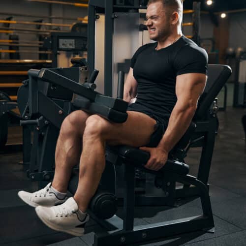 Homme s'entraînant sur machine de musculation.