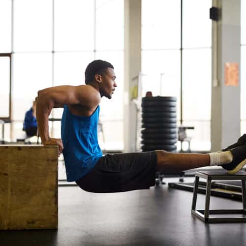 Homme faisant des exercices de triceps en salle sans matériel.