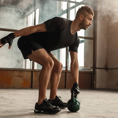 Homme faisant exercice avec kettlebell.