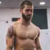 Homme musclé avec tatouage en salle de sport.
